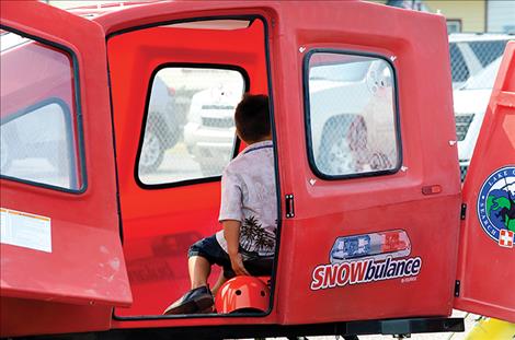 A child gets in the Snowbulance used by the LCSAR to rescue people on trails. 