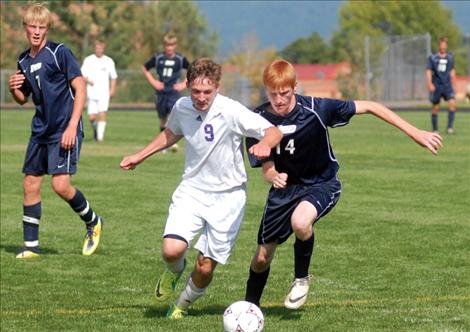 Polson High School soccer star James Larson, left, keeps the ball from a Loyola defender during a game last fall. 