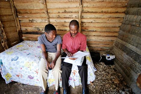 Joseph Benissois, right, queries Presandieu Charles on his mental state during a home visit in June. Benissois has worked as a community health worker in the Haitian town of Cange for more than 30 years.