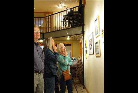 Gallery visitors look at artworks that highlight the intersection of art and agriculture.