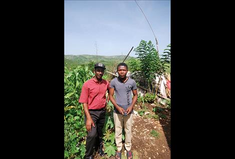Presandieu Charles, right, stands outside his home near Cange, Haiti, with community health worker Joseph Benissois.