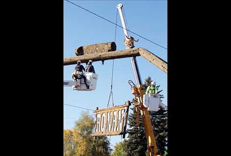 Crews from Access Montana and Mission Valley Power use a crane and a couple of boom lifts to bring the Ronan sign down.
