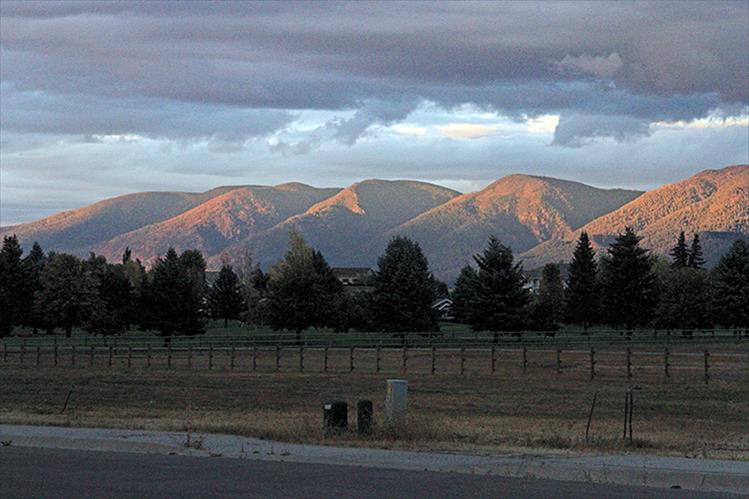 Final sunbeams cast a red glow on the mountains.