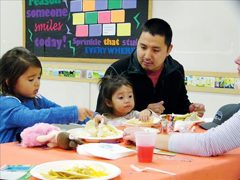 A family eats a meal together at the Arlee High School last week during a Family Dinner Project-themed event.