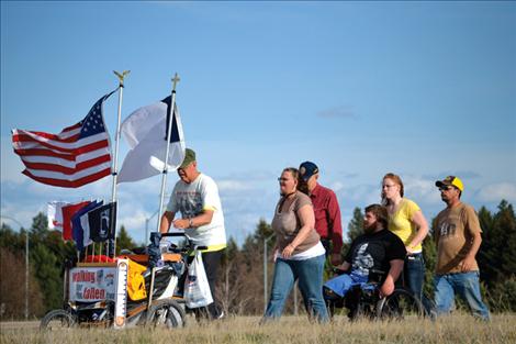 Veteran USMC Sgt. Chuck Lewis of Ronan enters Kalispell Friday evening, joined the last few miles by local veterans Ron Merwin and Tomy Parker, and several other supporters. 