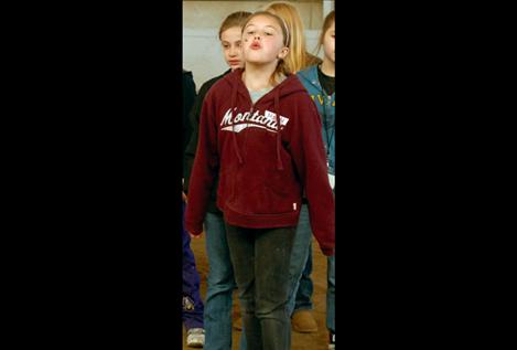 Left: A fourth-grader pretends she’s a leafy spurge and spits a  sunflower seed. Flathead Extension Agent Rene Kittle and program assistant Brenda Richey taught kids about seeds dispersing.