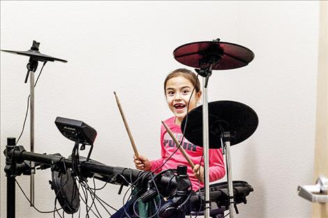 Molly Charlo tests out the drums at the new club's recording studio.