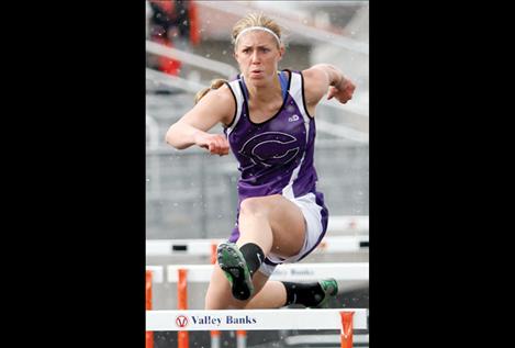 Rachel Hoyt clears a hurdle amid snow flurries at the Lake County meet April 30. The senior has an offer to run hurdles for Great Falls University, but she hopes to join the team at Montana State University-Bozeman.