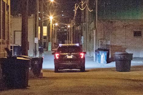 A Polson police  officer patrols a downtown alley during  evening hours.