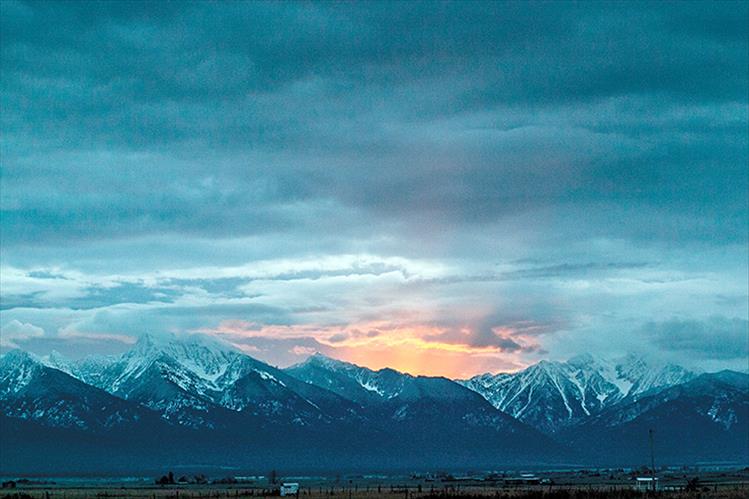 Breaking dawn: The sun's morning light warms the skyline behind the snowy Mission Mountain Range.