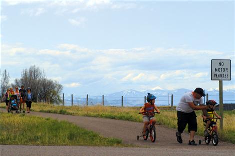 Left: Ashton Bird teaches Cage and Salmelin Bird how to stop, look and listen before crossing the street Mud Creek Lane during the Earth Day event. 