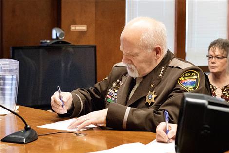 Sheriff Don Bell signs his oath of office.