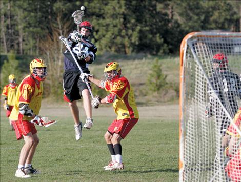 Tim Fitzpatrick fires a shot at the net over two Hellgate players last week in Pablo. Ten Sticks won the game 13-12.