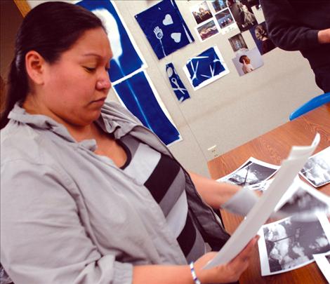 Cloud artist Linda Ferris looks over work prints, choosing images for the student show.
