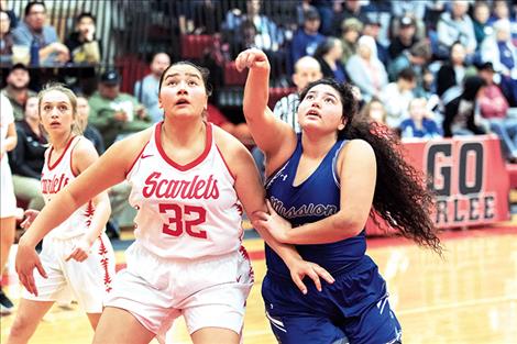 Scarlet Halle Adams and Lady Bulldog Addison Arlint battle for a rebound.