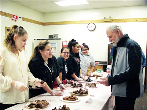 Arlee Girl Scouts serve samples to attendees.