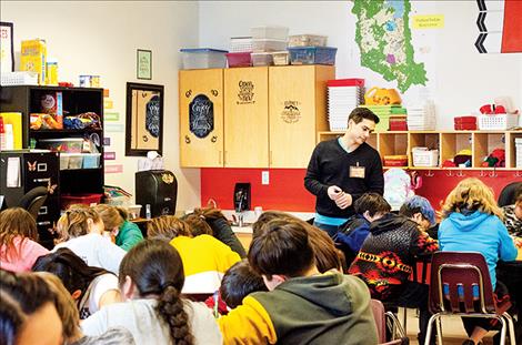Poet Alex Alviar with the Missoula Writing Collaborative works with a group of Pablo Elementary School students on a poetry writing project. 