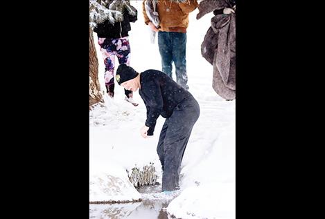 Ronan Chief of Police Ken Weaver eases his way into Spring Creek during Saturday's Flathead Rez Polar Plunge fundraising event to support the local Special Olympics program.