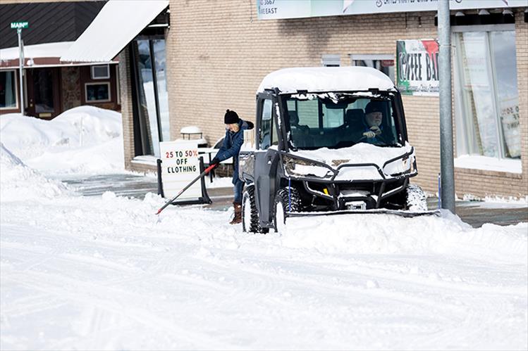 People work to remove snow from the sidewalks and streets of downtown Polson last week. Ten inches of snow fell between Sunday, Feb. 24 and Tuesday, Feb. 26.
