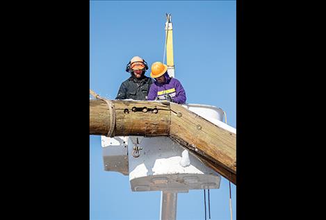 : Sackett and Robert Jennison of Jennison Tree Service clear snow off the arch before loosening the bolts. 