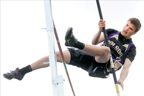 Dylan Kelley concentrates as he clears the bar in pole vault.