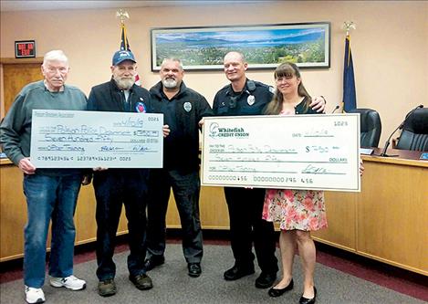 Presenting and accepting scholarship checks at City Hall on April 10 are, from left, Polson Shooters Association Treasurer Mauri Morin, PSA President Rob St. Clair; Polson Chief of Police Wade Nash and Sergeant George Simpson; and Lisa St. Clair,  Whitefish Credit Union Polson branch manager.