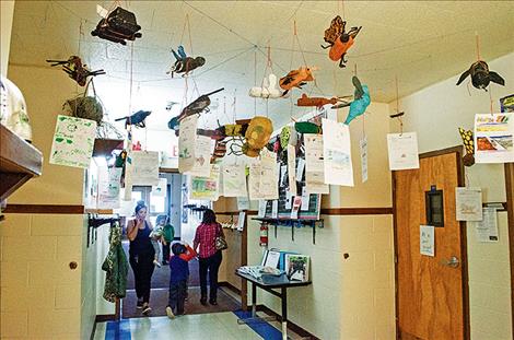 Student insects projects hang from the ceiling in the elementary school.