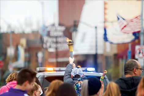 The Flame of Hope is carried high through downtown Polson.