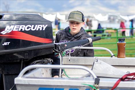  Polson seventh grader Christian Lund closely inspects a boat motor for aquatic invasive species.