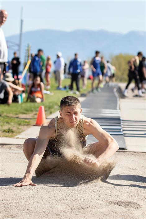 Sand explodes in the air as Polson Pirate Ryker Wenderoth lands in the long jump.