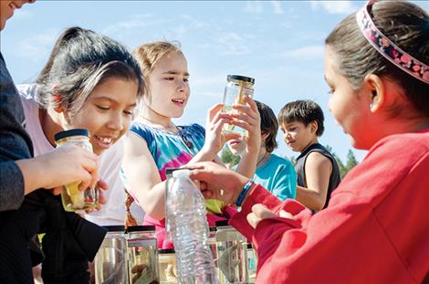 Different fish species in jars capture children's attention during the 33rd annual River Honoring. 