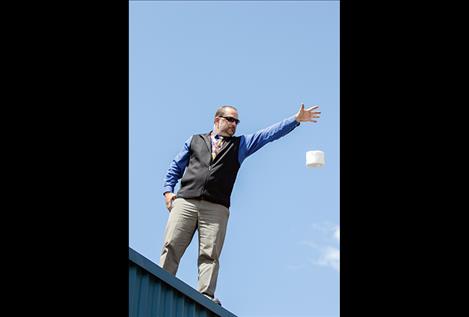 Pablo Elementary principal Mr. Fisher drops one of the students' egg  projects from the school roof.