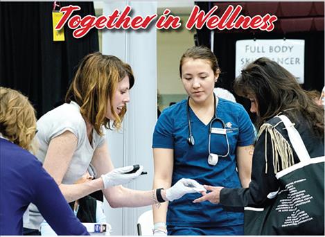 Dr. Hayley Miller with Community Medical Center provides diabetes screening tests during the Women 4 Wellness health fair. 