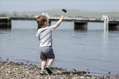 The youngest competitor of the event, Zander Avison heaves a few practice rocks into the lake.