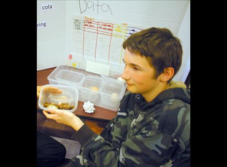 Jericho Hickenbottom shows off his project — an egg left in Cola for a week. The shell melted off and turned black while the rest of the egg deflated. 