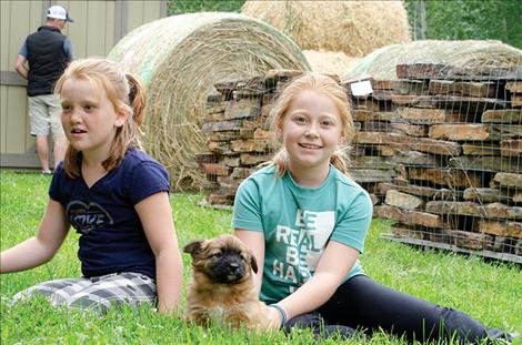 Peyton and Eva Hout watch the puppies. 