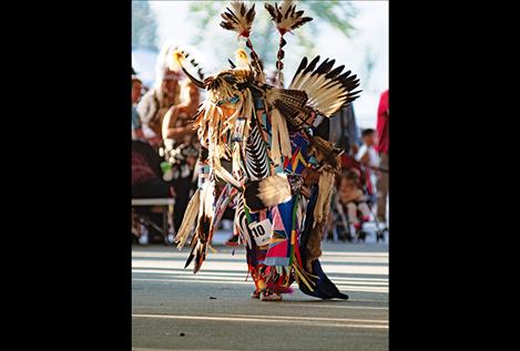 A man in full regalia participates in powwow dancing. 