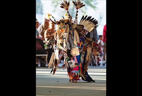 A man in full regalia participates in powwow dancing.