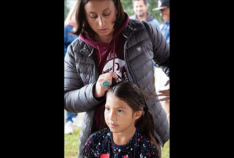 Olivia Ramirez gets her hair braided in prepartion for dancing on Saturday evening.