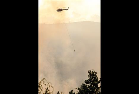 A helicopter helps fight the fire.