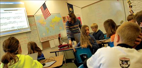 Gifted and talented teacher Tamara Fisher glances at the screen as sixth graders wait for a presentation by classmate MaKauly Morrison.  