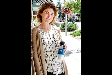 Shelley Cleverdon  holds one of the  The Giving Pool  water bottles while standing in Polson. 