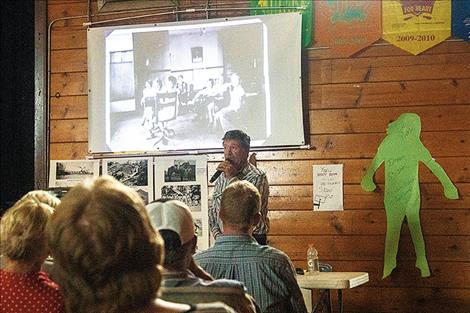  People share stories in the gym where  historic photos were displayed during the 100th year celebration. 