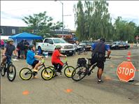 Police officers distribute bicycle safety helmets to kids