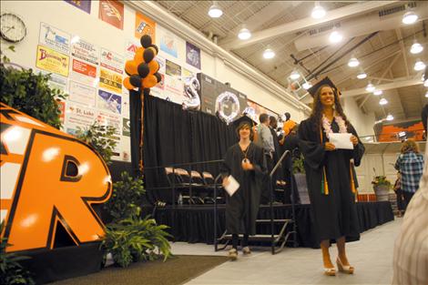 Having just received her diploma, senior Ashleigh Lynch smiles and poses for a photo near the stage.