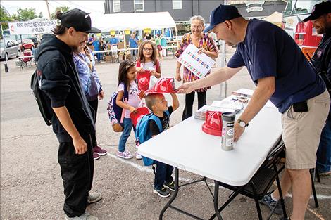 Polson City firefighters give toy helmets to kids.