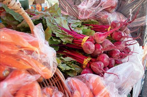 Fresh radishes and carrots await purchase at the Polson Farmers Market.