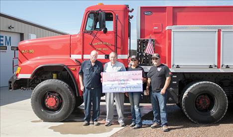 Standing with a check representing funds for new firefighting equipment for their new water tender truck, above, are from left: Fire Chief Gordon Gieser, District Board Chairman Fred Nelson, membership treasurer/secretary Jane Clapp and membership president Jeff Veach.