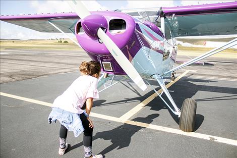 Youngster Olivia Ramirez takes a close-up look at the plane she called cotton candy because of its purple color.
