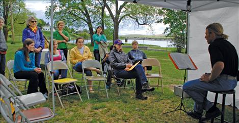 Gary Morley reads “Talking Hard Work” by Woody Guthrie as the audience listens. Annabelle Smith, left, and Sophie Sisler, yellow jacket, planned the PoArtry event. 